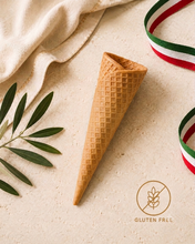 Load image into Gallery viewer, A single waffle cone-shaped utensil or prop lies on a light beige textured surface with a draped cream cloth, green leaves, and red-white-green ribbon. A circular 'Gluten Free' logo appears in the lower right.